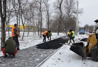 В снег асфальтировали тротуар в г. Шахты около гипермаркета «Лента»