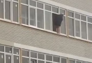 Женщина шокировала горожан своим мытьем окна на большой высоте без страховки [Видео]